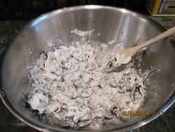 How to Make White Chocolate Oreo Bark - Pour the melted vanilla bark over the crushed Oreos. Stir evenly.